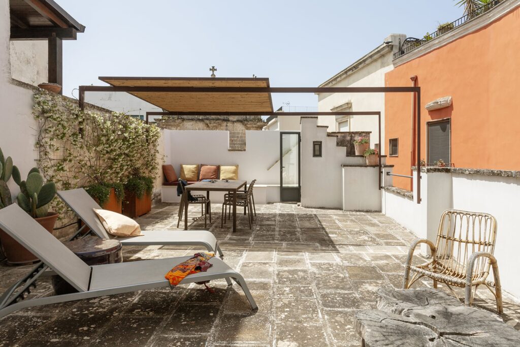 Rooftop terrace with pergola shade, dining table and sun loungers at La Botte, Nardò