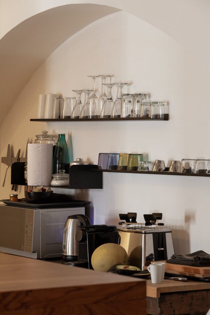 Kitchen counter detail with glassware shelves and espresso machine, La Botte, Nardò