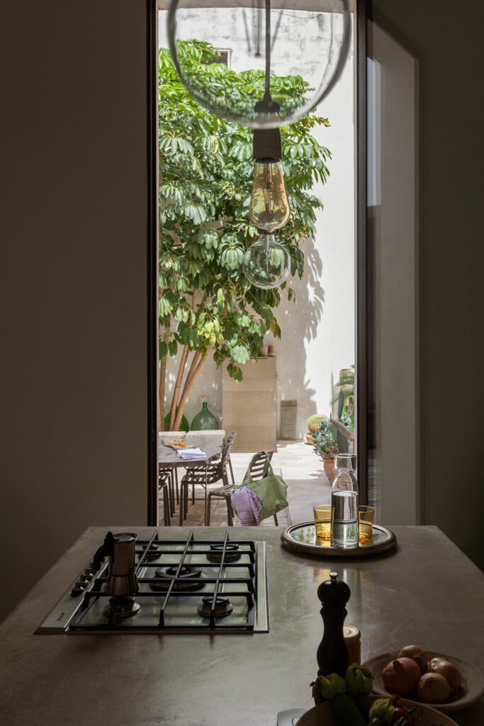 Kitchen stovetop framed by the courtyard doorway, La Corte palazzo, Nardò