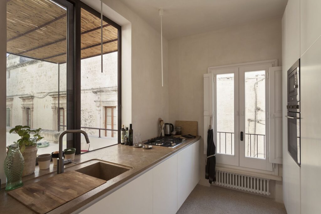 Kitchen with marble counter and French doors onto a Juliet balcony, Teatro house, Nardò