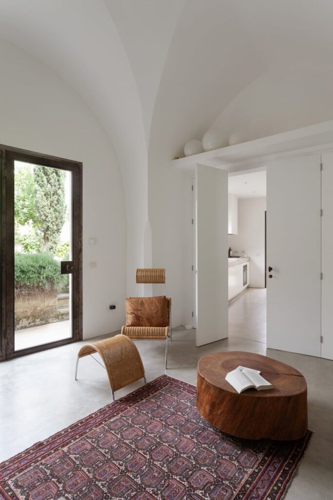 11. Agrumeto_Nardòsalento_Credits40Mirrors_114_living room Living room corner with a leather chair and tree-trunk coffee table, La Casa Grande, Nardò