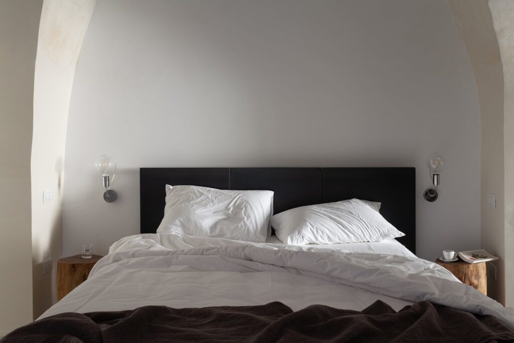 Bedroom 1 headboard detail with wall sconces, Agrumeto house, Nardò