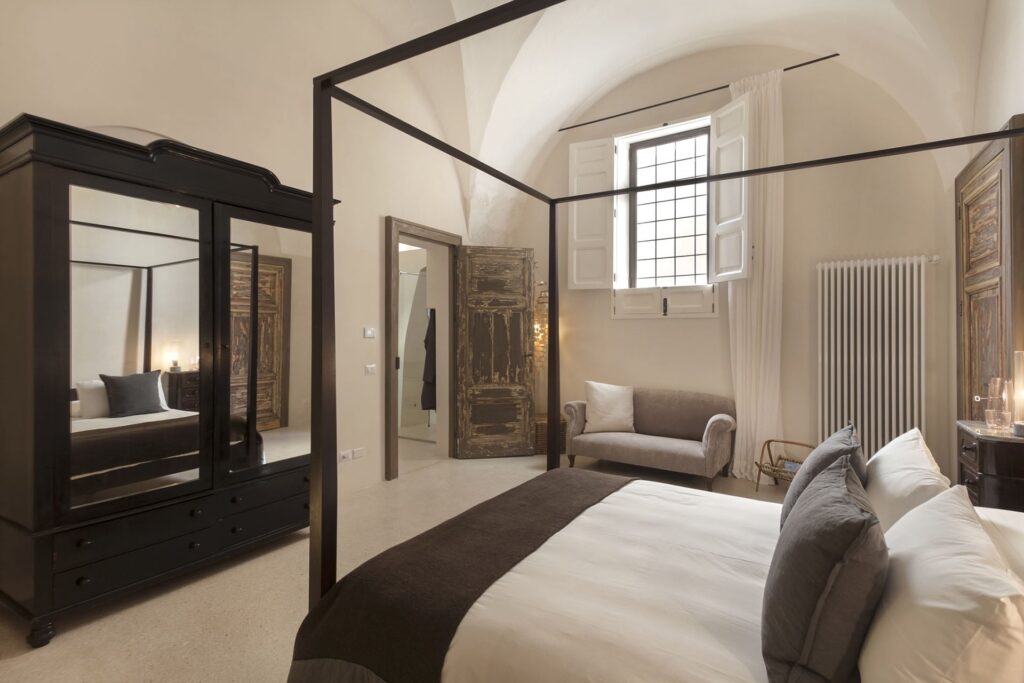 Master bedroom with black four-poster frame and vaulted ceiling, Teatro house, Nardò