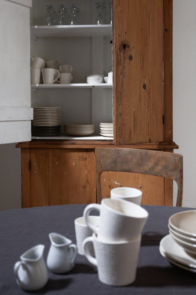 Antique cabinet with ceramic dishware above the dining table, La Corte, Nardò