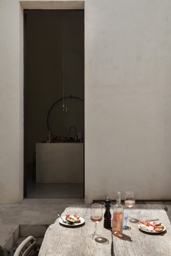 Courtyard dining table set for lunch, view toward the kitchen, La Corte, Nardò