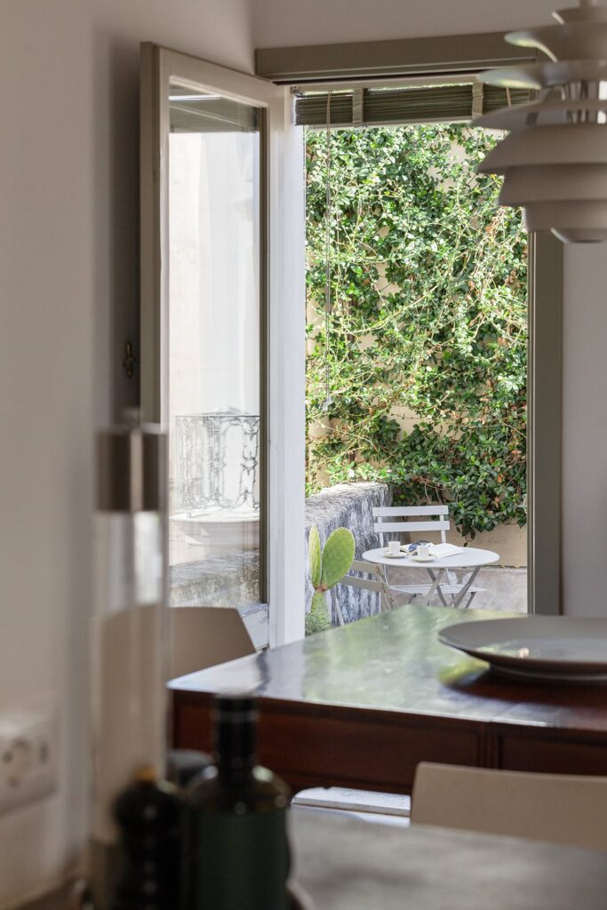 15. Angelo_Custode_Nardòsalento_Credits40Mirrors_50_Dining room detail Dining room door open to a small ivy-covered balcony, Angelo Custode, Nardò