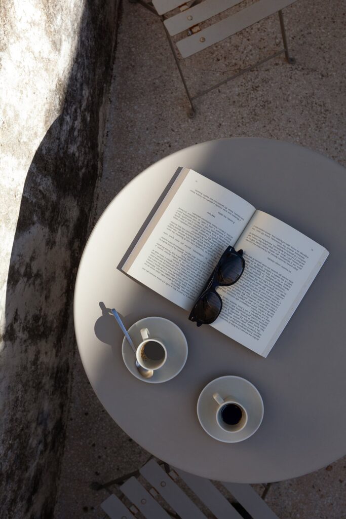 17. Angelo_Custode_Nardòsalento_Credits40Mirrors_52_First floor balcony detail Balcony table set with coffee, a book and sunglasses, Angelo Custode, Nardò