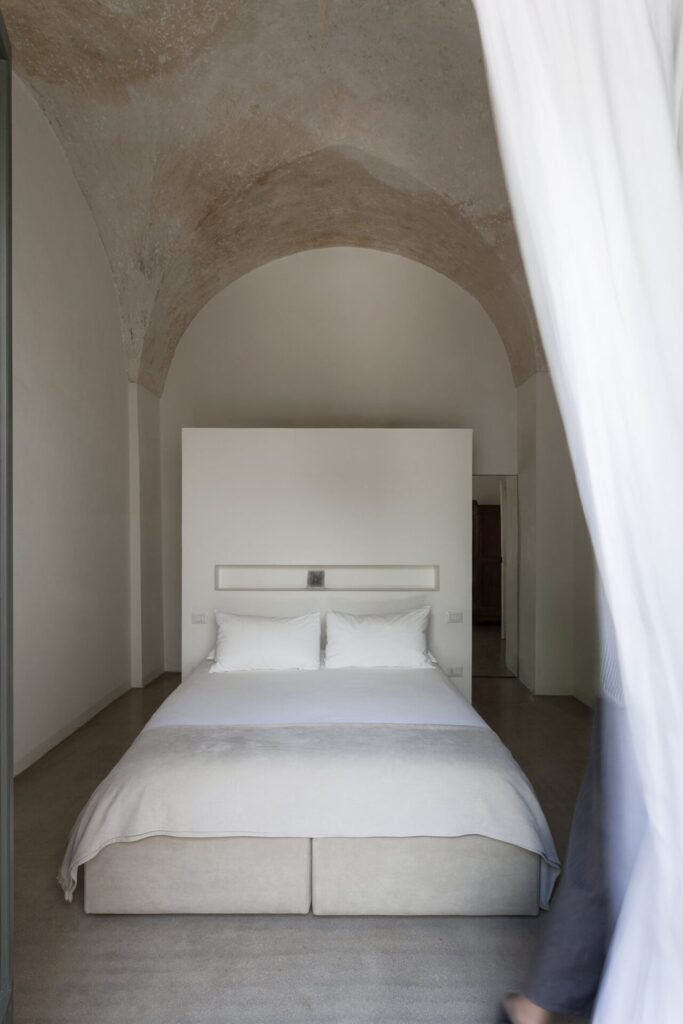 17. La_Corte_Nardòsalento_Credits40Mirrors_camera2_016_Bedroom 2 Bedroom with vaulted stone ceiling and minimalist platform bed, La Casa Grande, Nardò