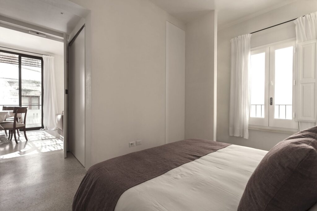 Second bedroom with terrazzo floor and a glimpse of the terrace, Teatro house, Nardò