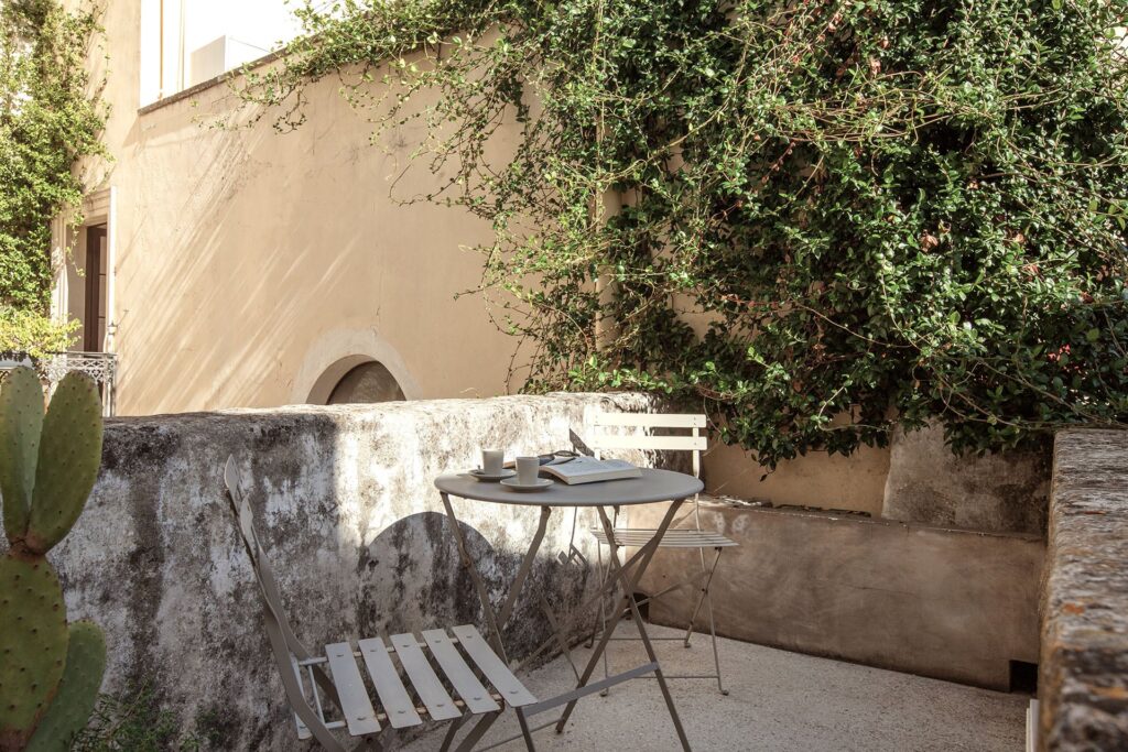 18. Angelo_Custode_Nardòsalento_Credits40Mirrors_1954_First floor balcony First-floor balcony with bistro chairs against an ivy-covered wall, Angelo Custode, Nardò