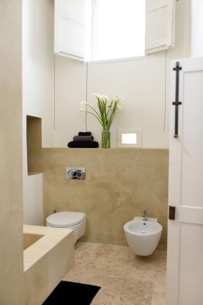 Master ensuite bathroom with fresh flowers and dark towels, La Corte, Nardò