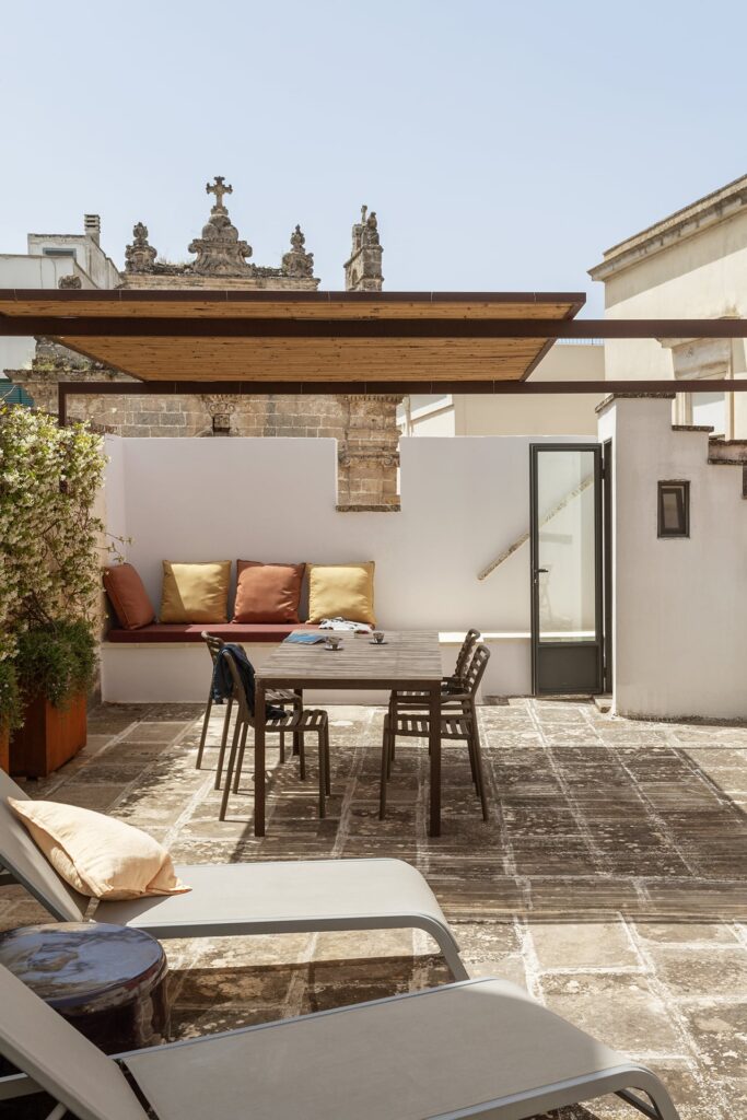 Rooftop terrace dining table with a baroque church facade behind, La Botte, Nardò