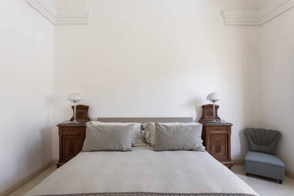 21. Angelo_Custode_Nardòsalento_Credits40Mirrors_10_Master bedroom Master bedroom with matching antique nightstands and a scalloped armchair, Angelo Custode, Nardò