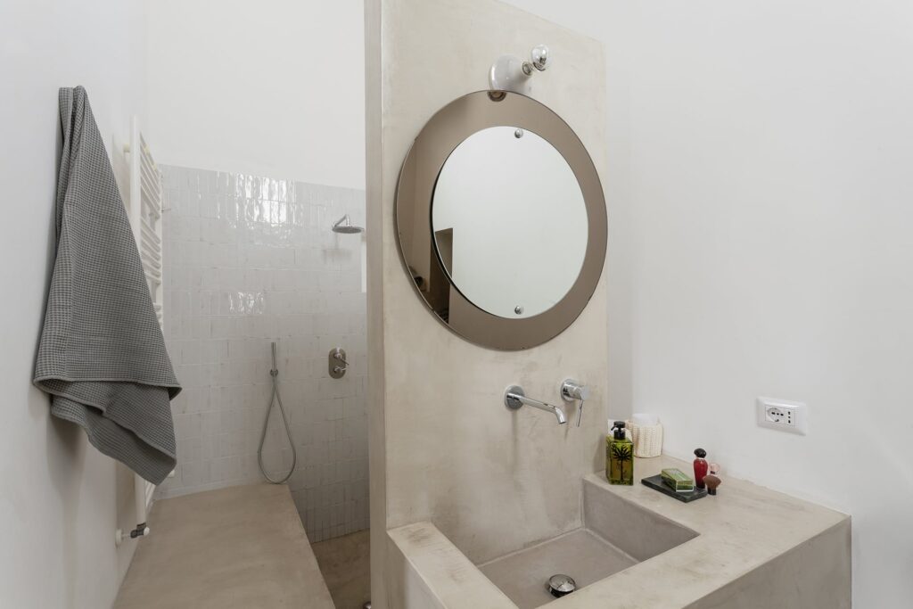 Master ensuite bathroom with round mirror and walk-in shower, La Corte, Nardò