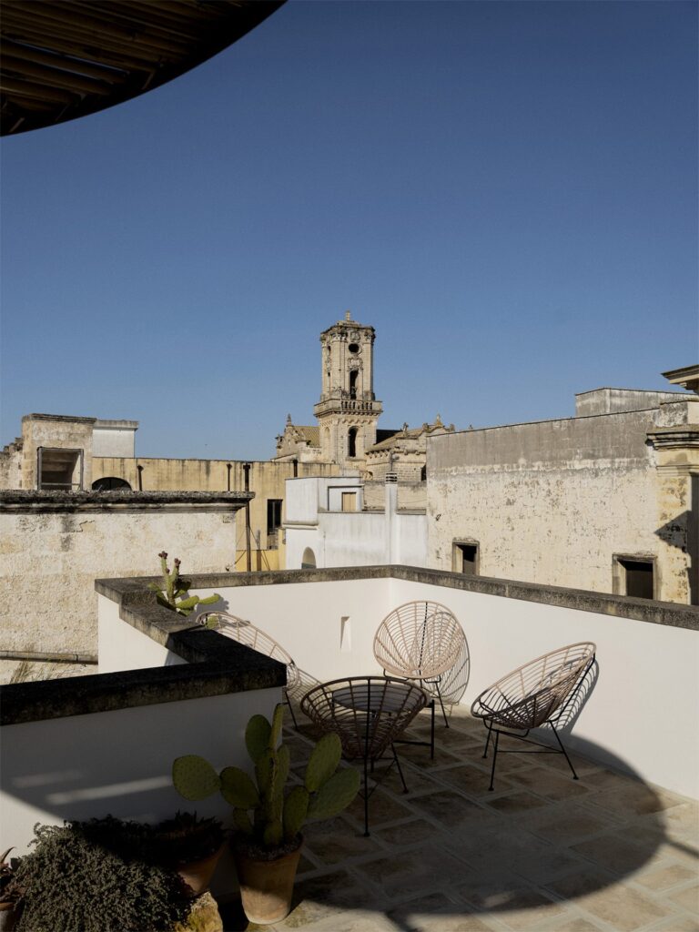 Rooftop terrace lounge chairs facing the bell tower of Nardò, Teatro house