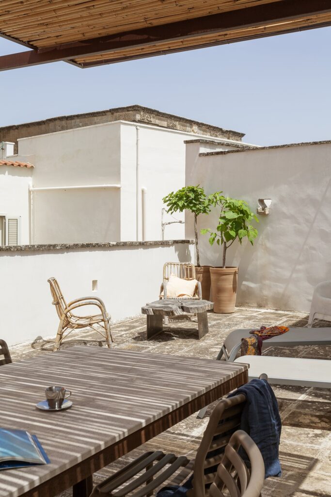 Rooftop terrace corner with potted fig tree and wicker chair, La Botte, Nardò