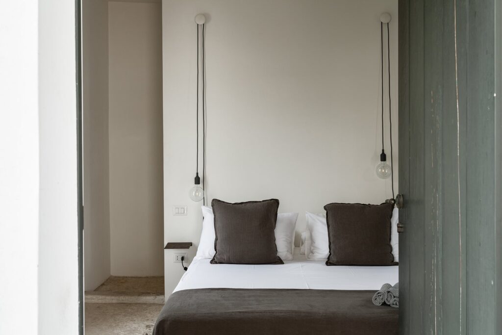 First-floor bedroom 3 with pendant bulb lights either side of the bed, La Corte, Nardò