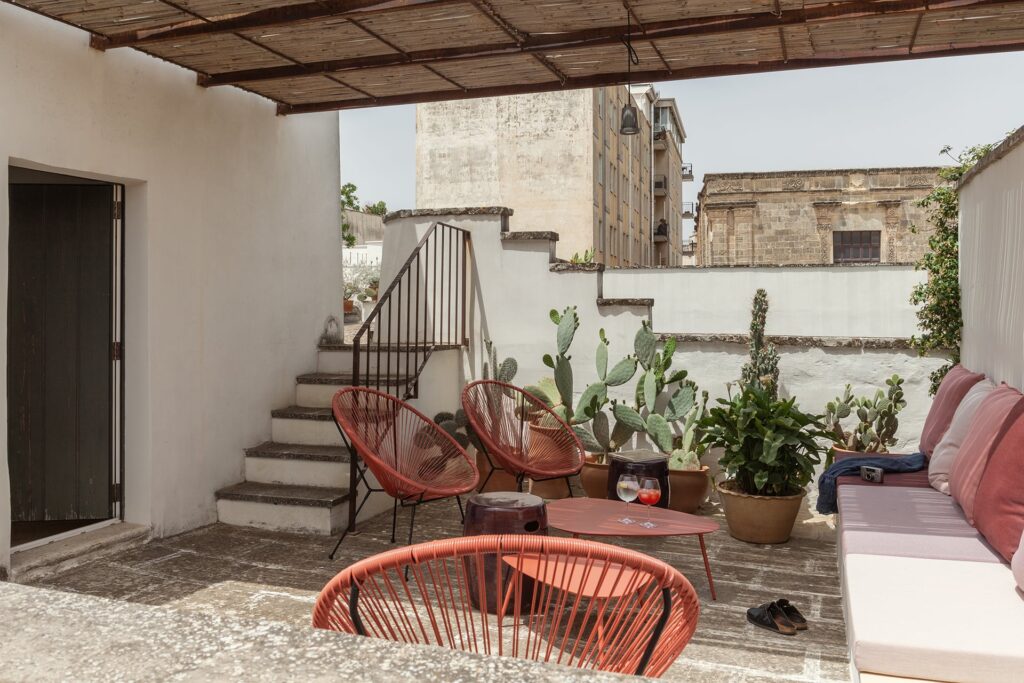 Rooftop lounge with terracotta chairs beneath a reed pergola, La Corte, Nardò