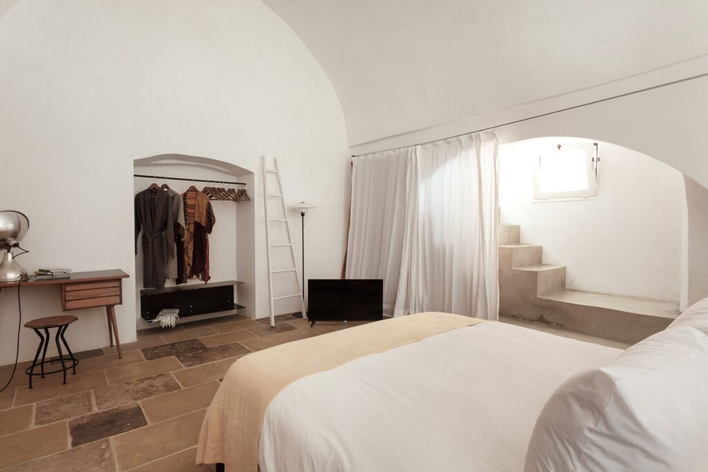 Vaulted bedroom with open wardrobe niche and steps to a window nook, La Botte, Nardò