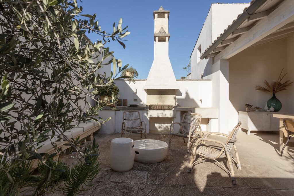 6. Angelo_Custode_Nardòsalento_Credits40Mirrors_62Intermediate terrace and terrace shed and summer kitchen Outdoor summer kitchen with brick chimney and rattan chairs, Angelo Custode terrace, Nardò