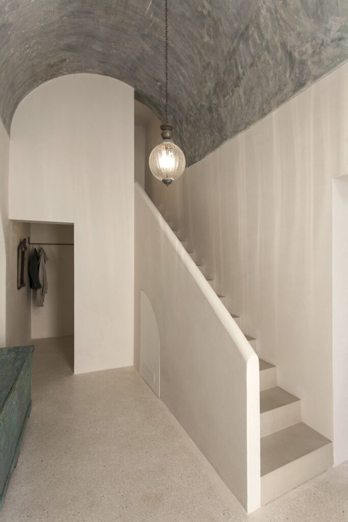 Entry hall staircase beneath a textured vaulted ceiling, Teatro house, Nardò