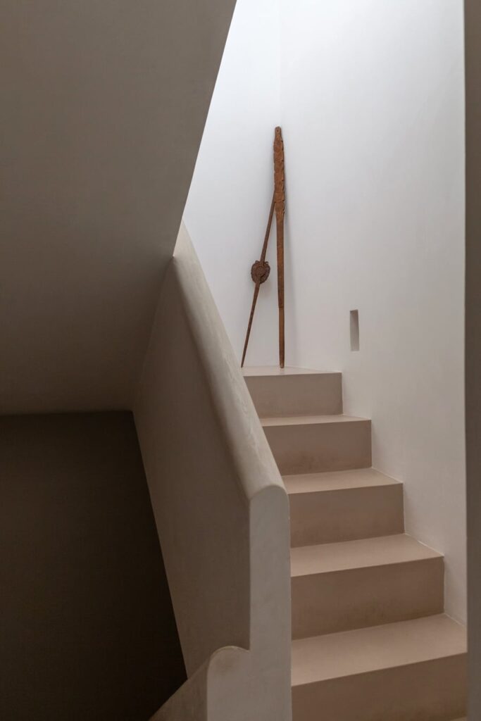 Staircase to the rooftop terrace with a sculptural wood accent, Teatro house, Nardò