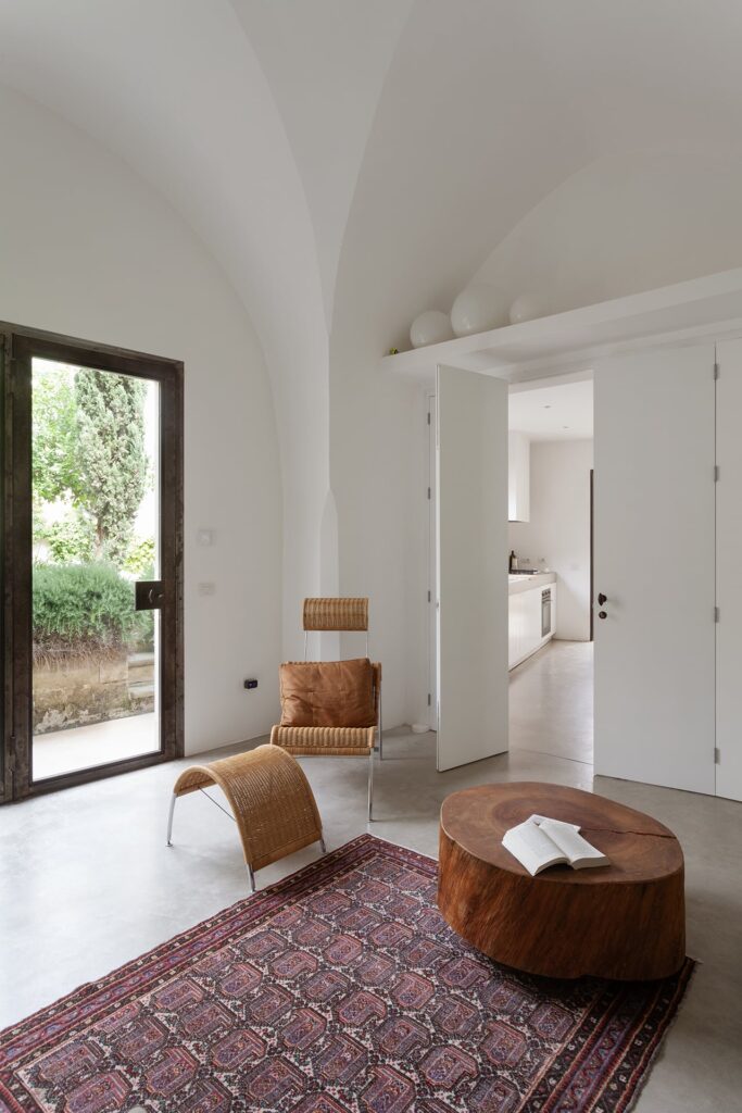 Living room corner with a leather chair and tree-trunk coffee table, Agrumeto house, Nardò