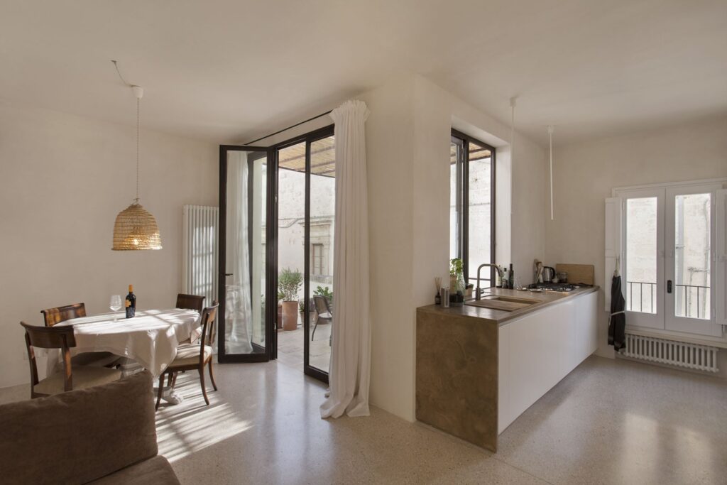 Open-plan living and kitchen area with doors to the terrace, Teatro house, Nardò